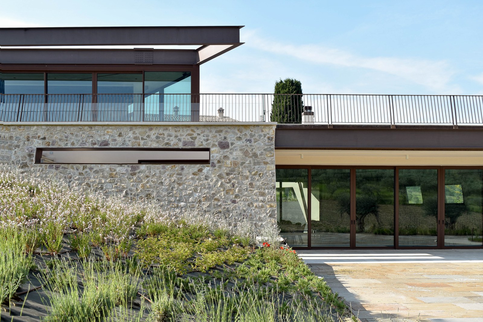 Agriturismo Alma, Assisi — stone walls and glass volumes emerging from the hillside